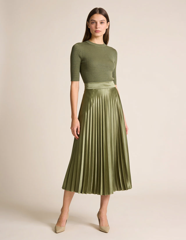 Woman wearing sage green pleated satin midi skirt