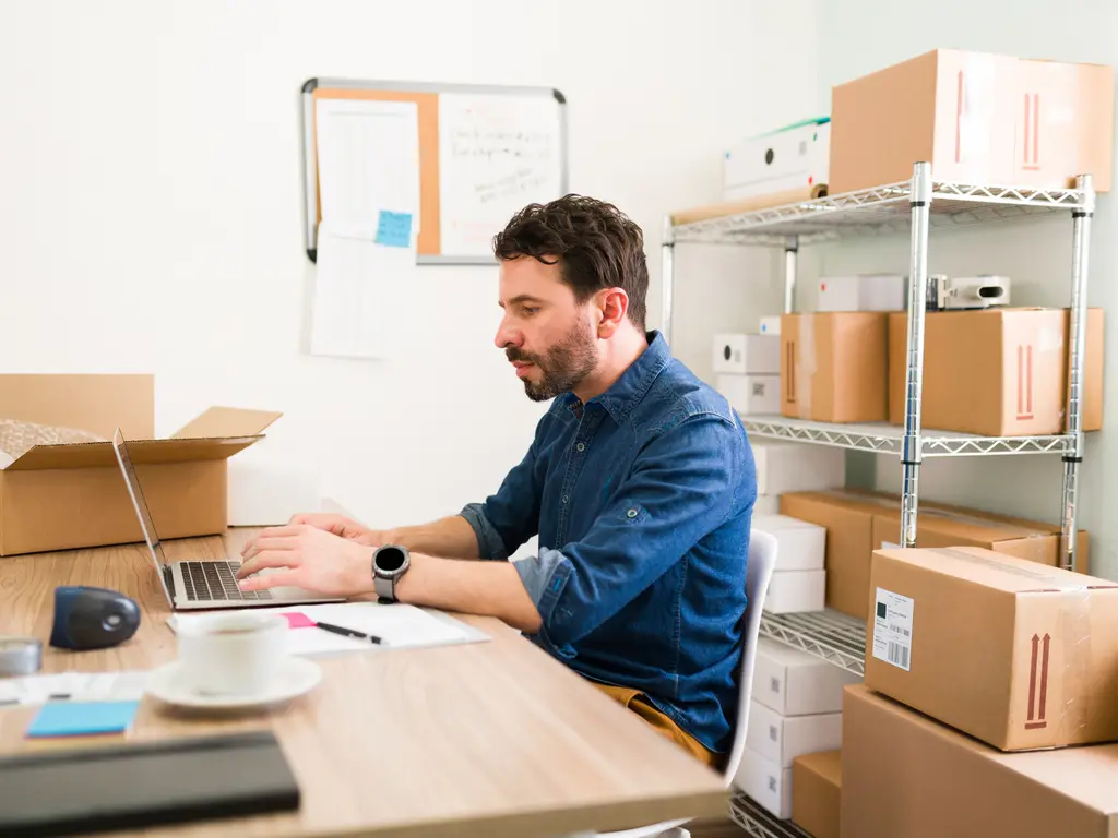 A shop owner adding new products to their online store on a laptop (illustrative photo)