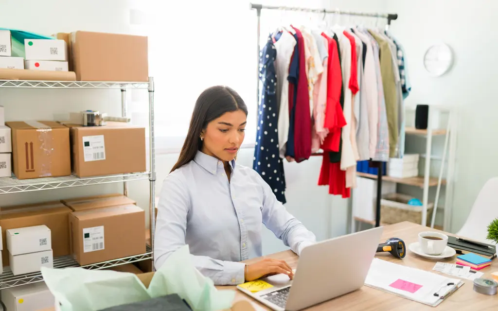 A store owner at a desk updating product information for an online shop (illustrative photo)
